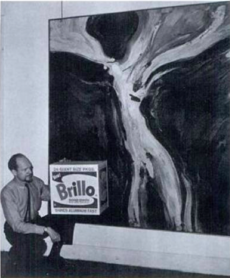 James Harvey with pne of his abstract paintings and holding the more famous Brillo box